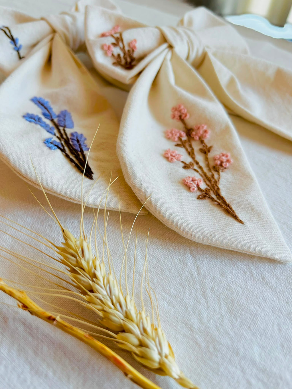 Moña Isabella bordada en lino con lavanda y flores rosadas