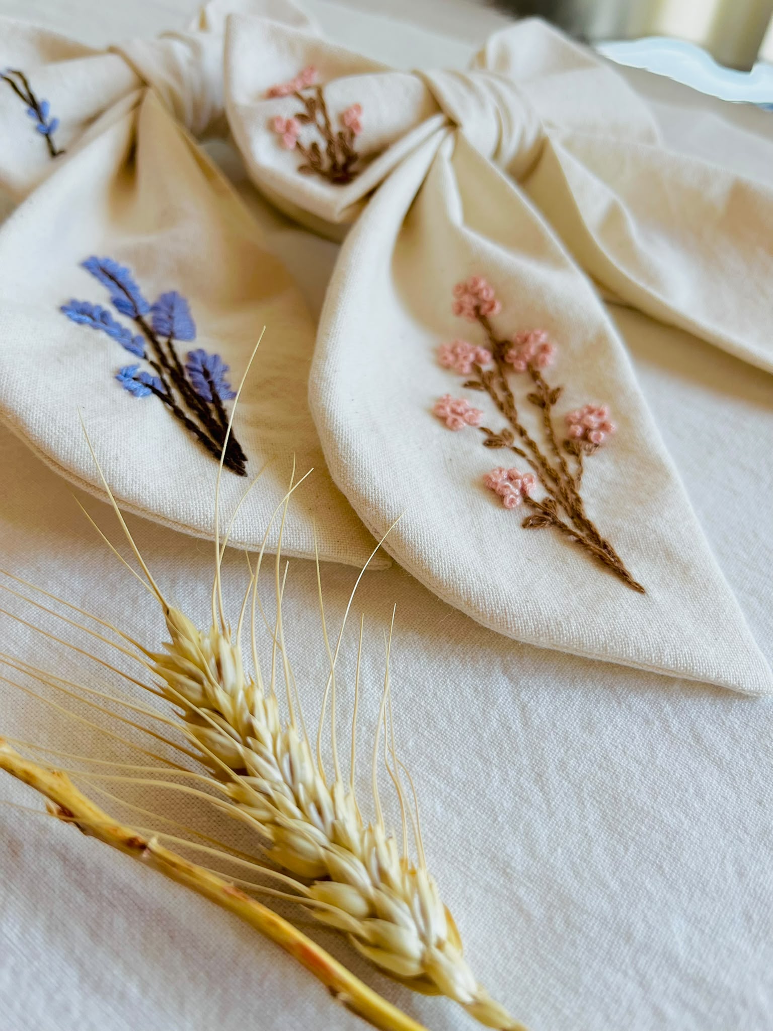 Moña Isabella bordada en lino con lavanda y flores rosadas